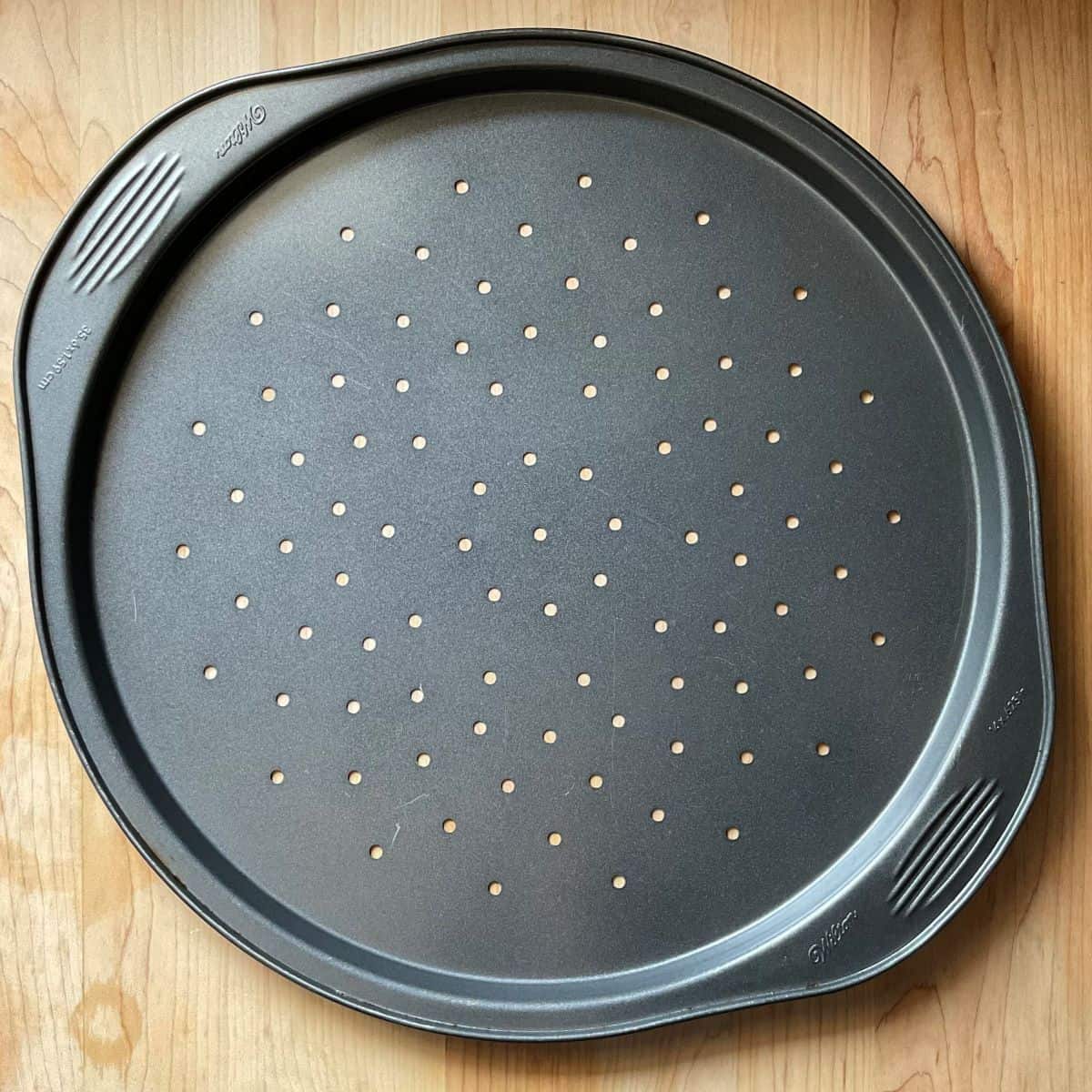 A perforated pizza pan to make escarole pie.