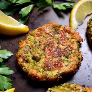 Broccoli fritters with parsley and lemon wedges.