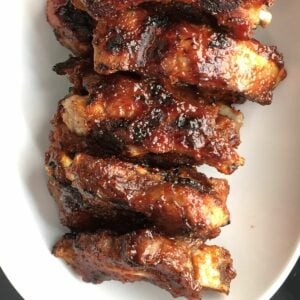 Oven baked ribs on a white platter.