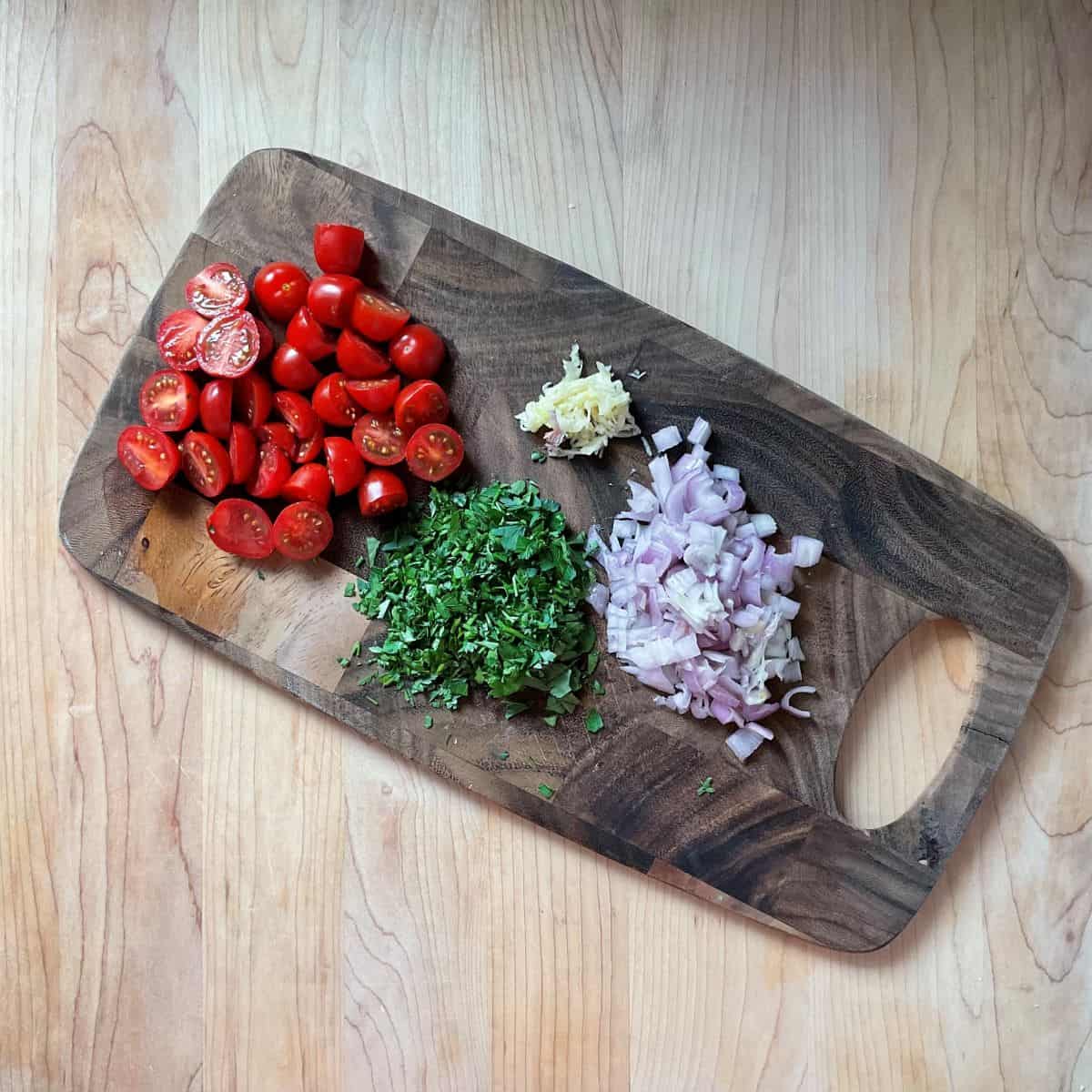 Minced ingredients on a wooden board.