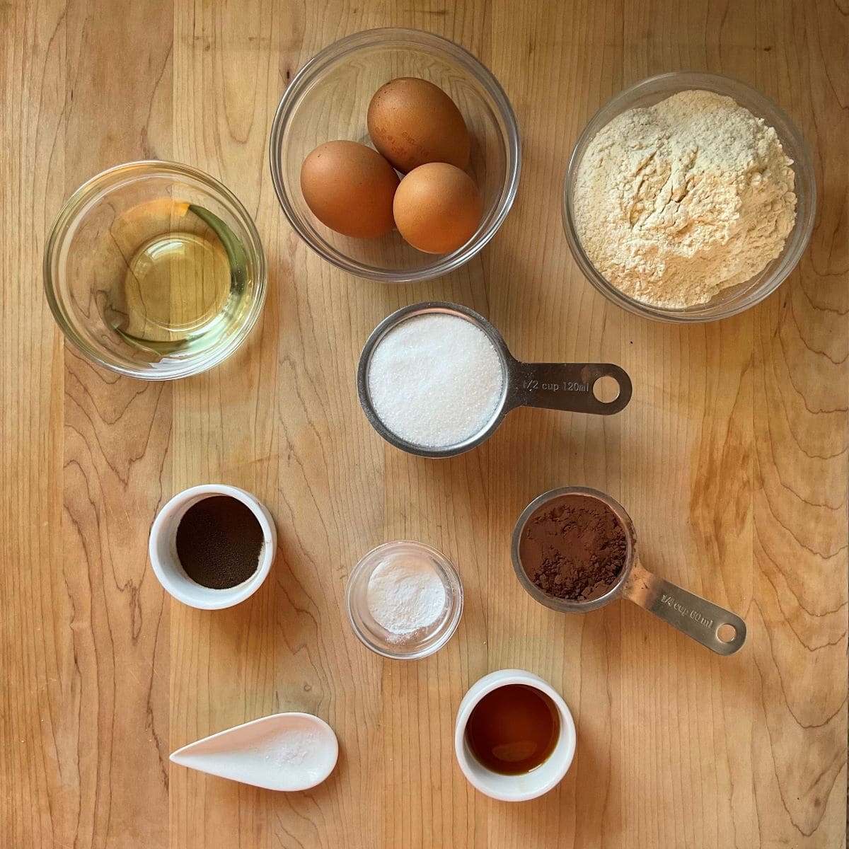 The ingredients to make a chocolate pizzelle recipe on a wooden board.
