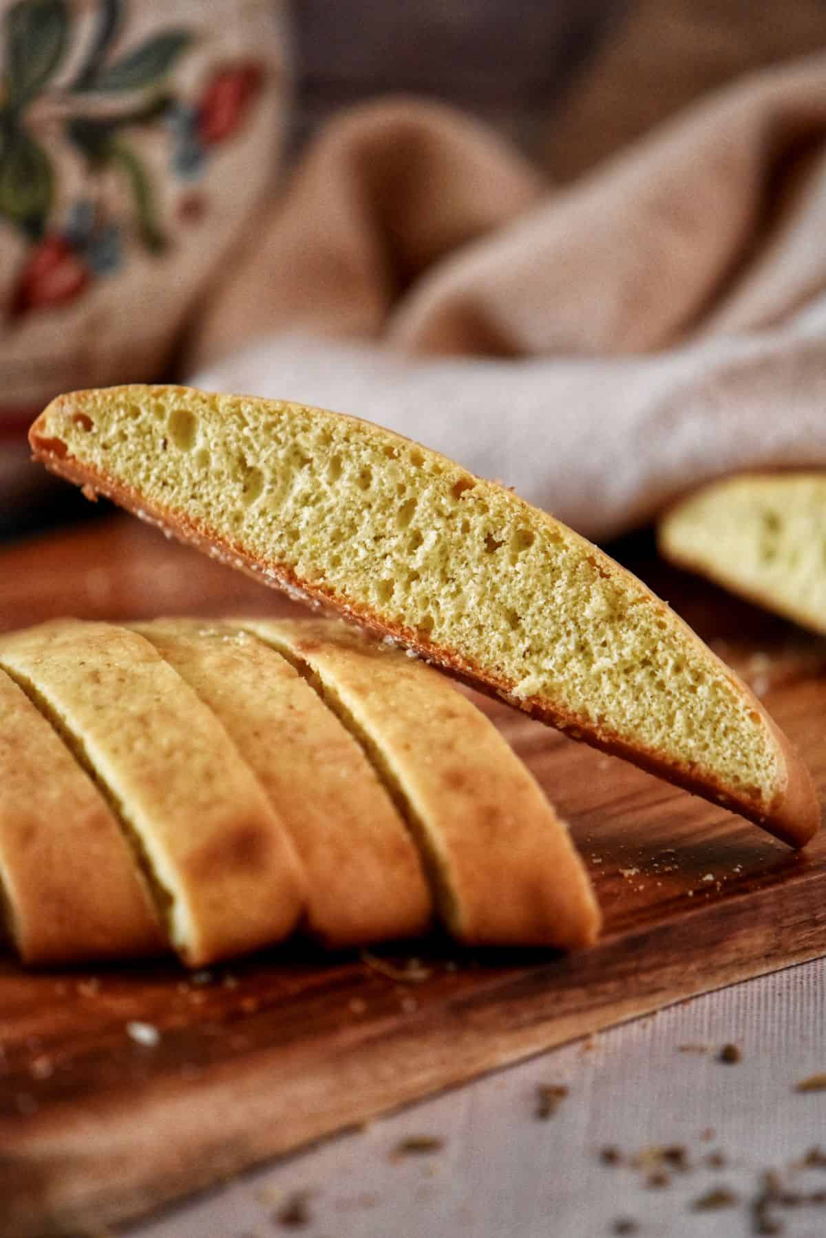 Sliced anise sponge cookies on a wooden board.