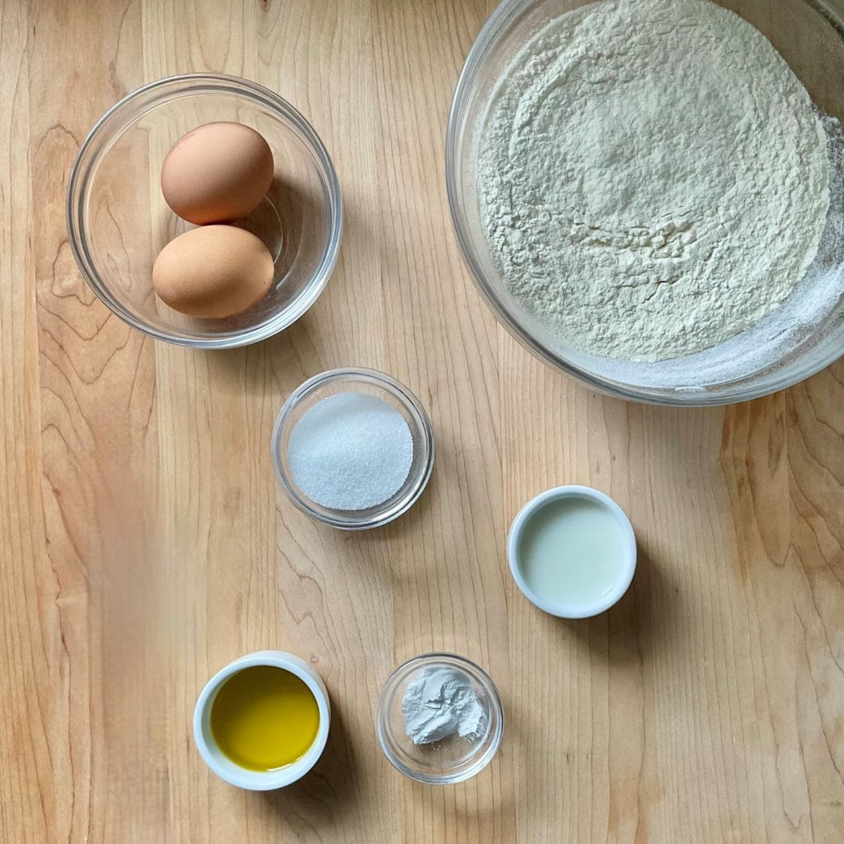 Ingredients to make Italian taralli on a wooden board.