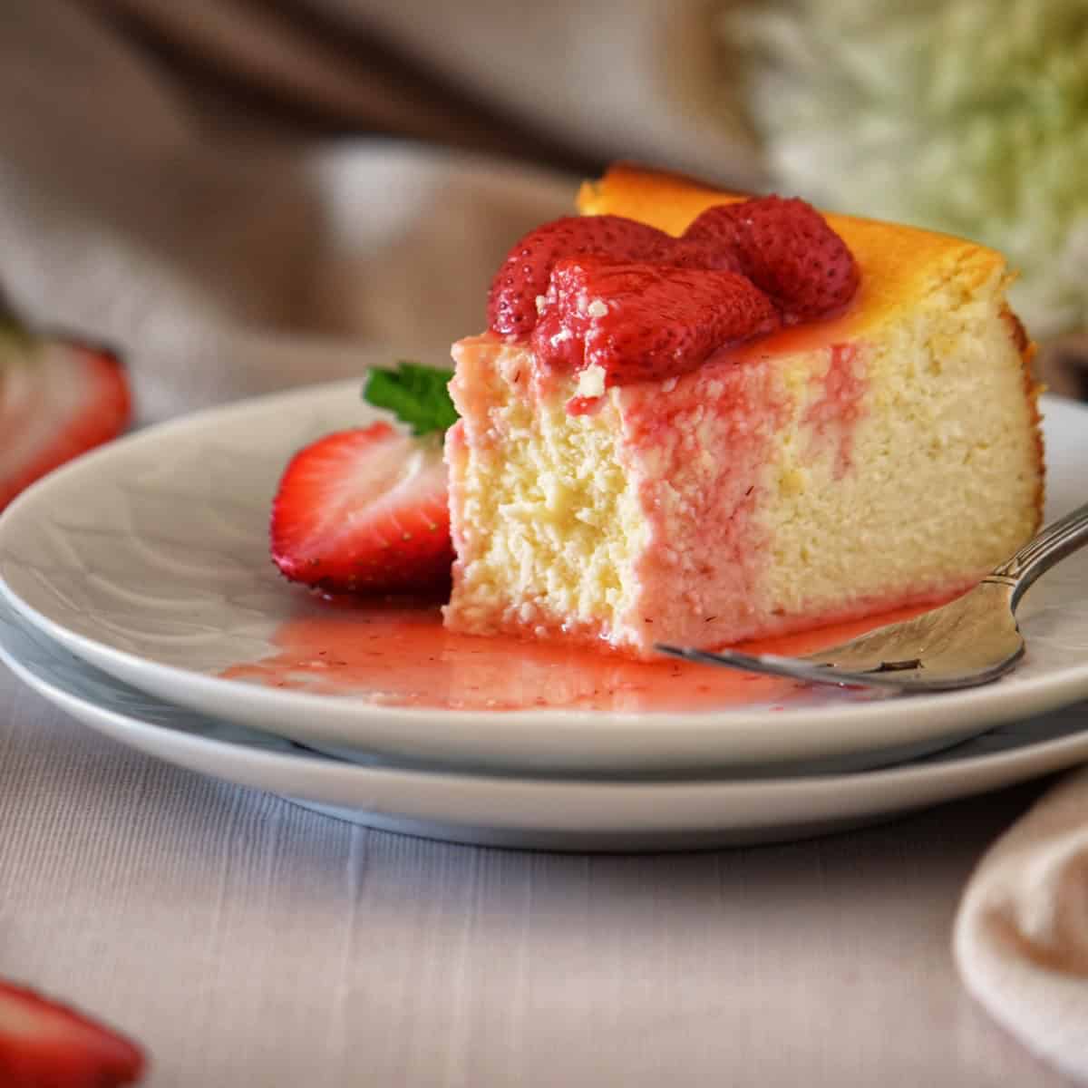 A slice of ricotta cheesecake on a white plate.