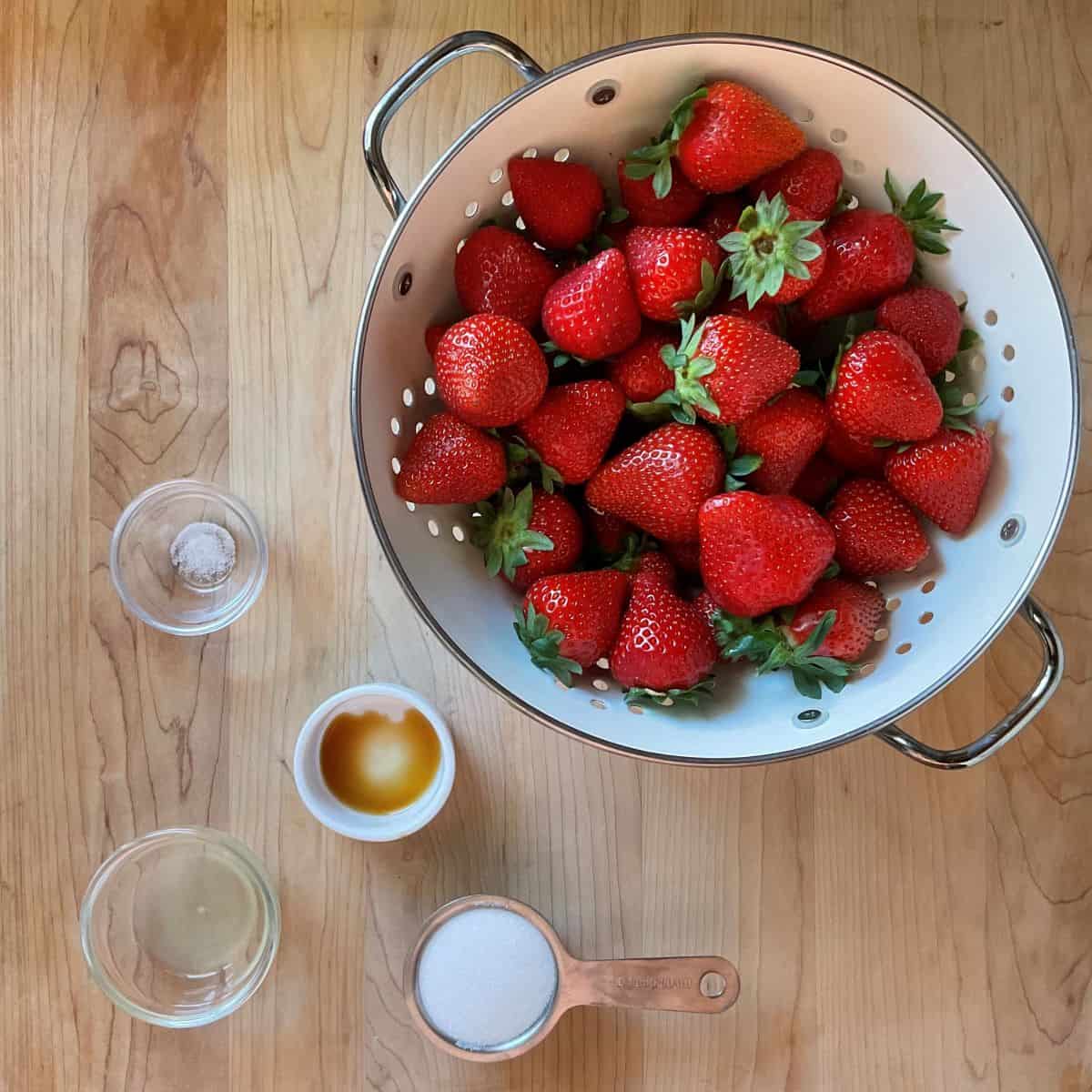 Ingredients for roasting strawberries on a wooden table.