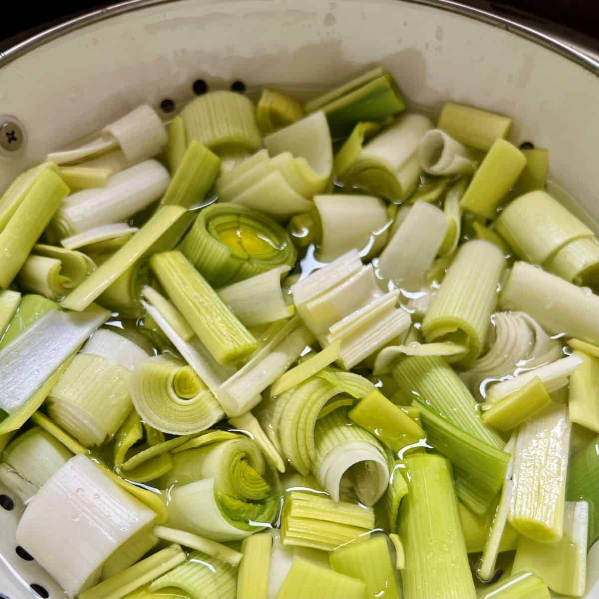Chopped leeks in a colander.
