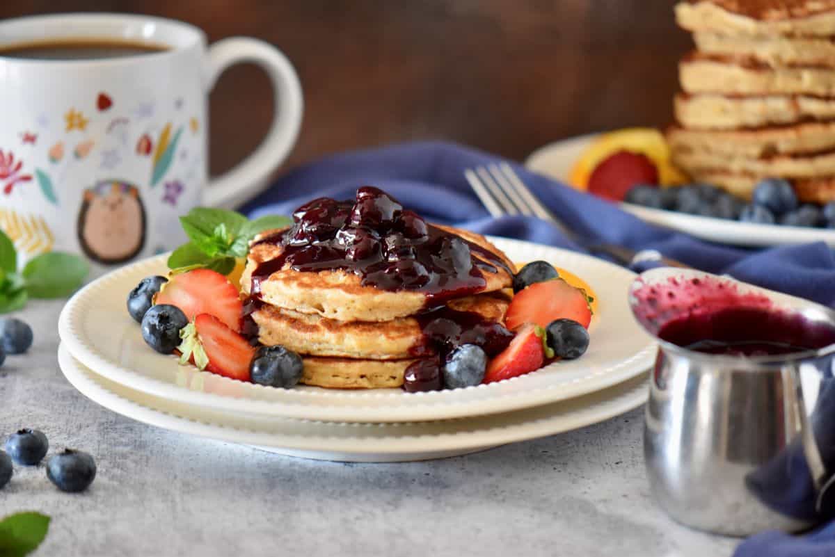 Fluffy pancakes served with a blueberry compote on top.
