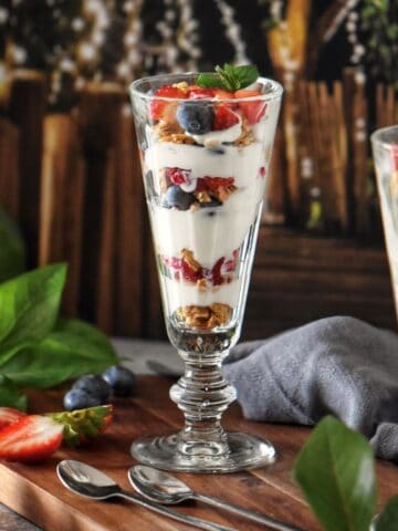 A fruit parfait with whipped ricotta in a parfait glass.