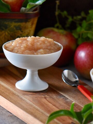 Slow cooker applesauce in a white dessert dish freshly made and ready to enjoy.
