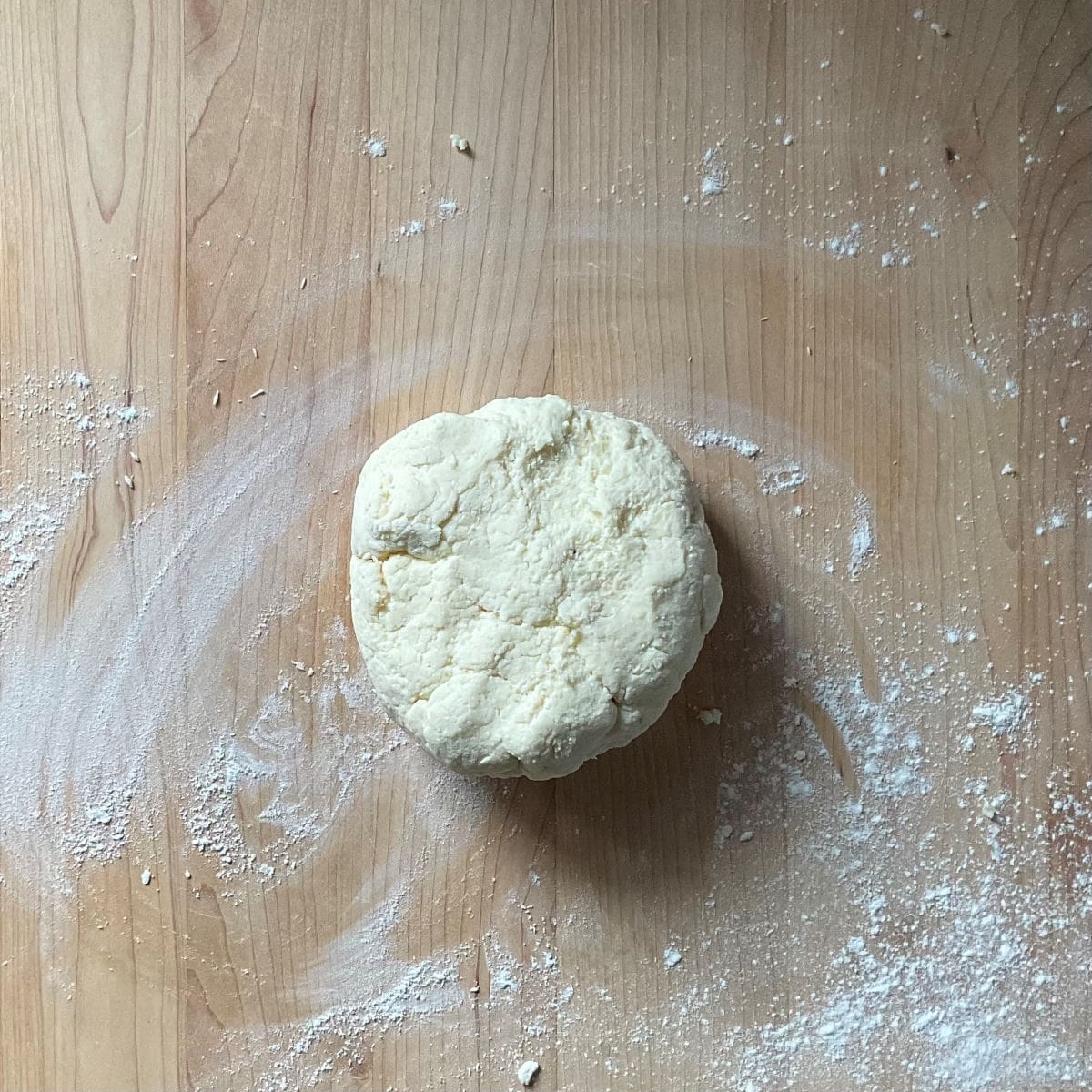 The gnocchi dough resting on a floured wooden board.