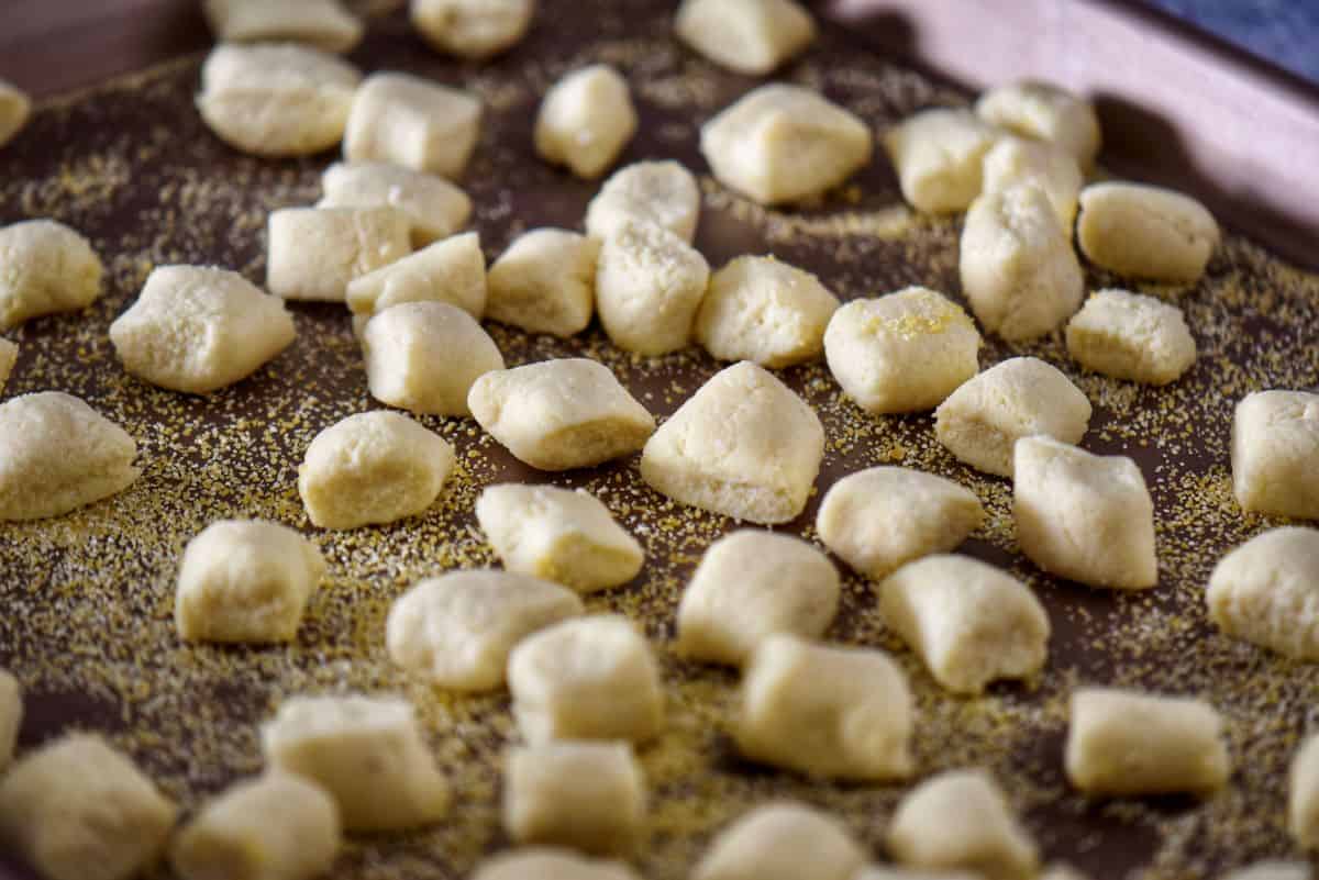 A tray dusted with semolina with ricotta gnocchi resting on it.