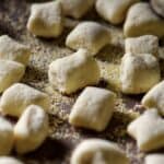 A tray dusted with semolina with ricotta gnocchi resting on it.