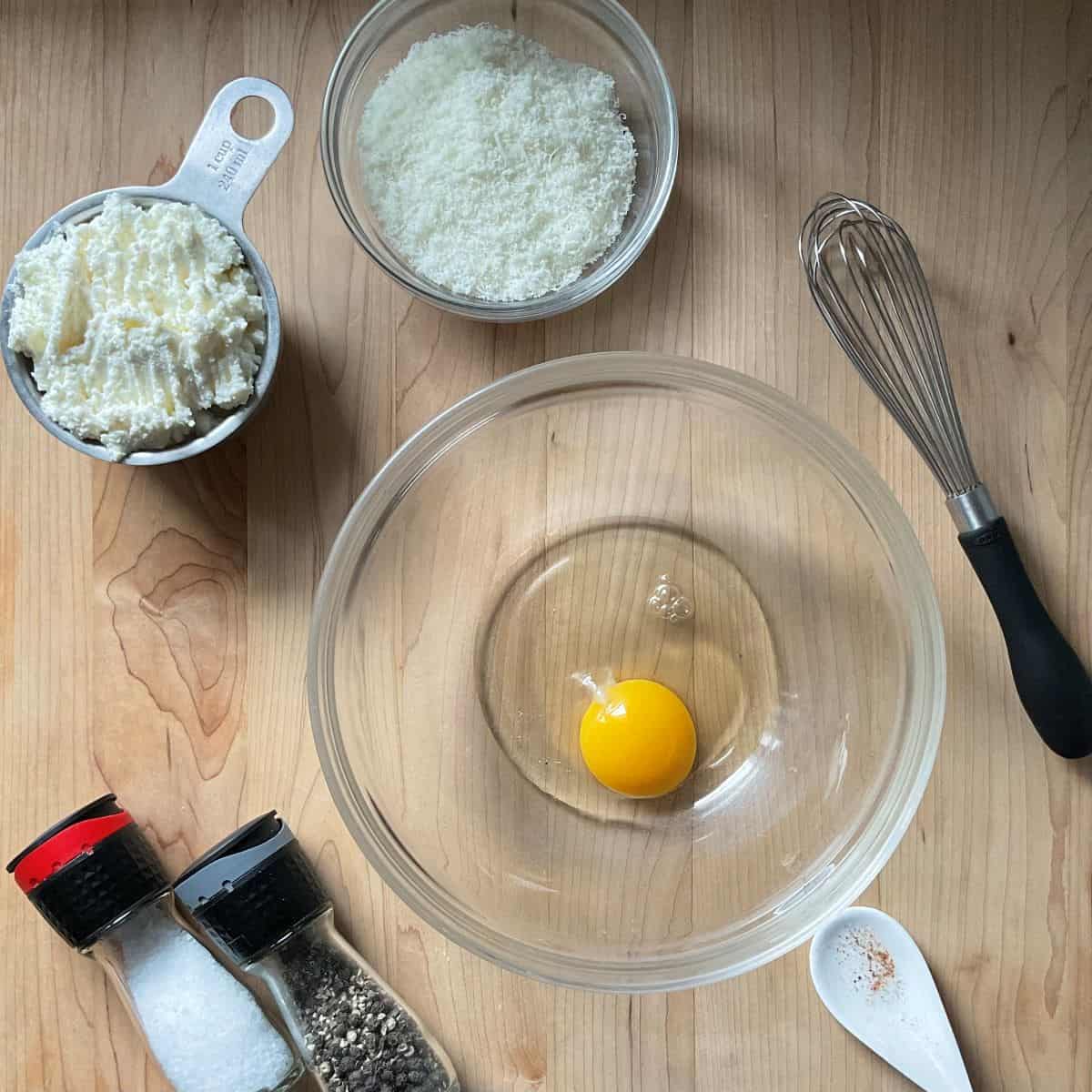 The ingredients to make ricotta gnocchi on a wooden board.