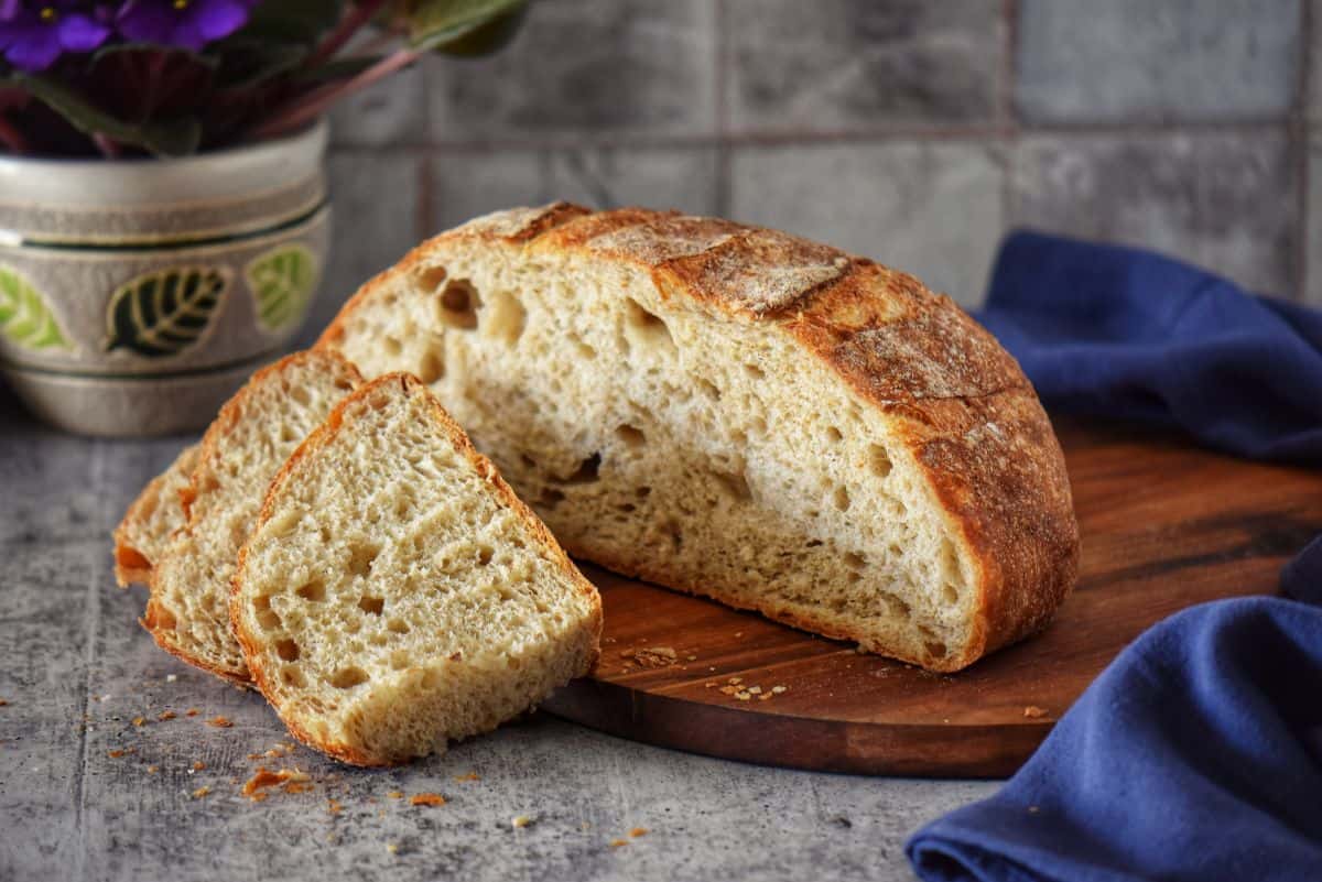 Sliced crusty Italian round bread showing the airy texture.