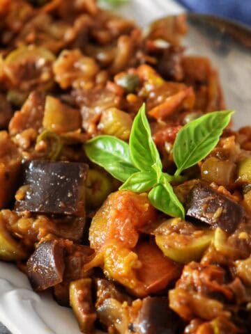 Close-up view of eggplant caponata appetizer, a Sicilian-inspired dish with eggplant, tomatoes, olives, and capers.