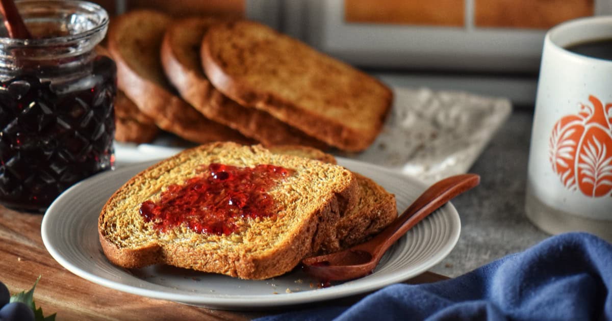 Italian toast with grape jelly on a white plate.