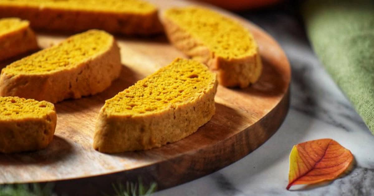 Slices of pumpkin spice biscotti on a wooden board.