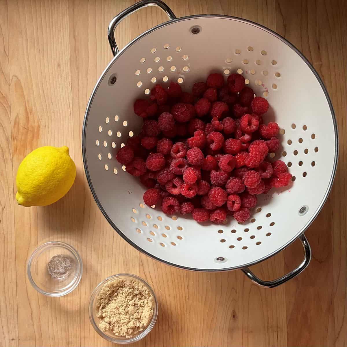 Ingredients for easy raspberry compote including fresh berries and brown sugar.