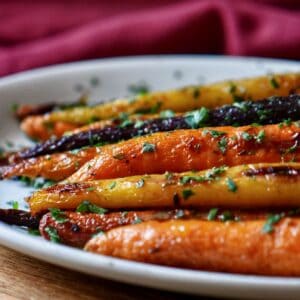 Colorful roasted rainbow carrots garnished with fresh parsley, ready to serve.