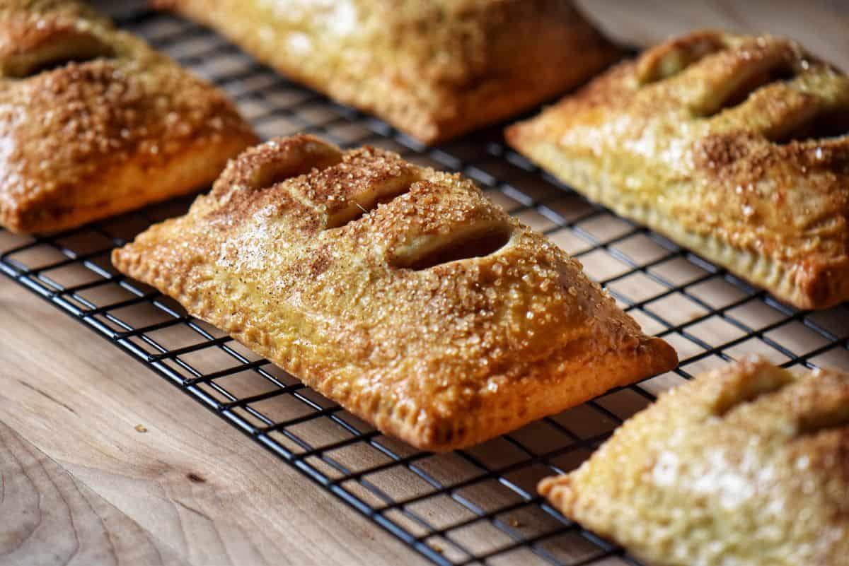 Apple hand pies on cooling rack displaying perfectly sealed edges and golden brown crust.