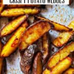 Golden, crispy baked potato wedges on a parchment-lined baking sheet, fresh from the oven.