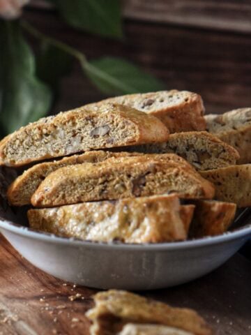 Crunchy Italian biscotti with orange peel and pecans stacked in a bowl.