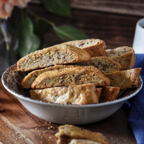 Crunchy Italian biscotti with orange peel and pecans stacked in a bowl.