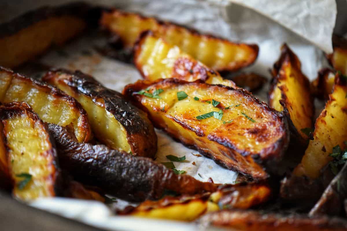Crispy oven-baked Yukon potato wedges sprinkled with fresh Italian parsley.