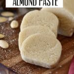 Almond paste log sliced into a few even rounds on a wooden cutting board.