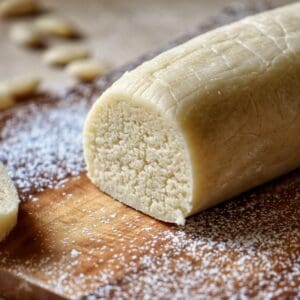 Close-up of an almond paste log on a wooden board.