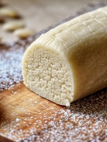 Close-up of an almond paste log on a wooden board.