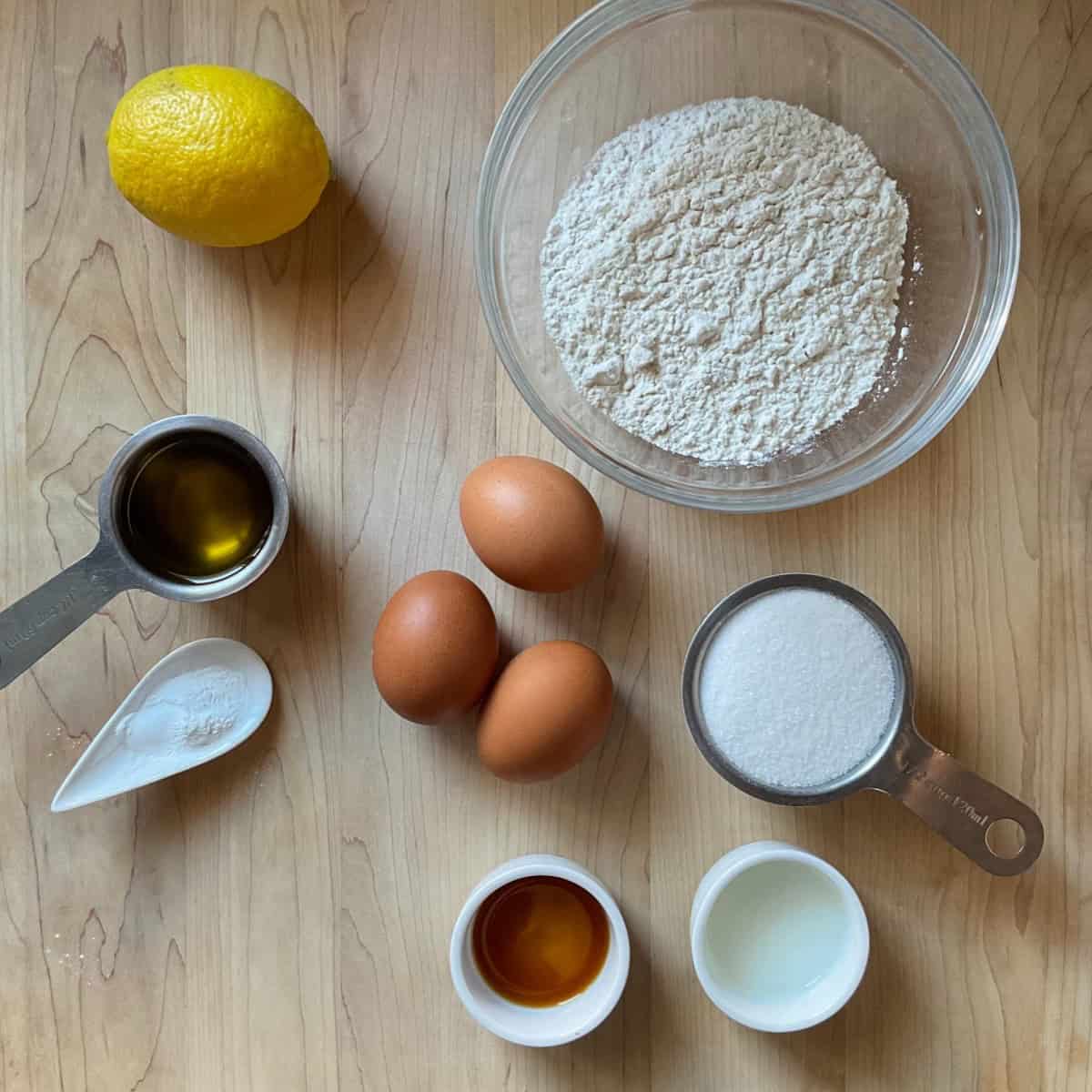 Lemon pizzelle ingredients on a wooden surface.