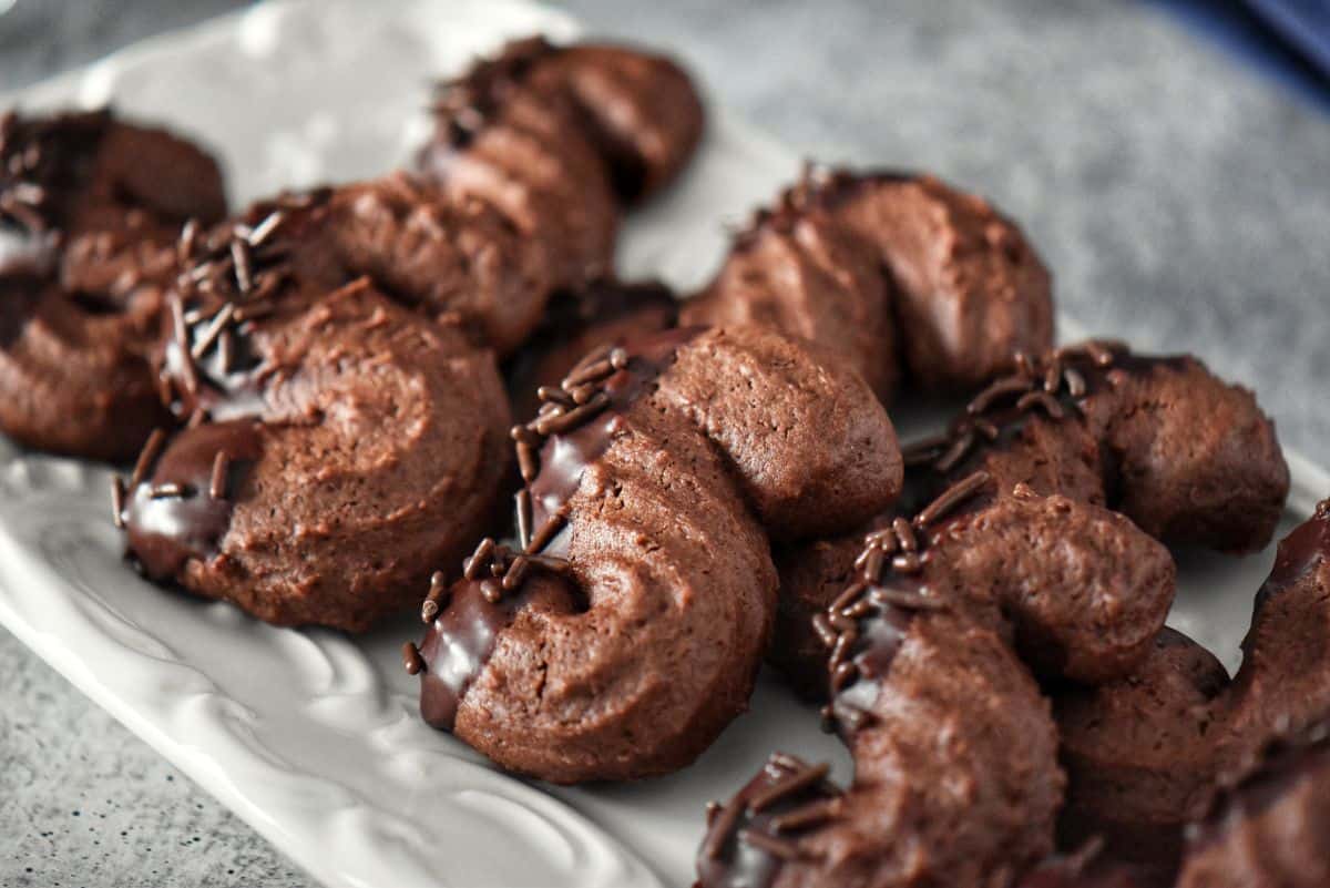 Chocolate S cookies on a white platter.
