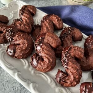 Chocolate S cookies on a white platter.