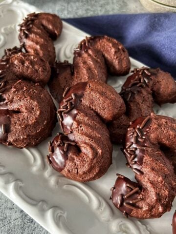Chocolate S cookies on a white platter.