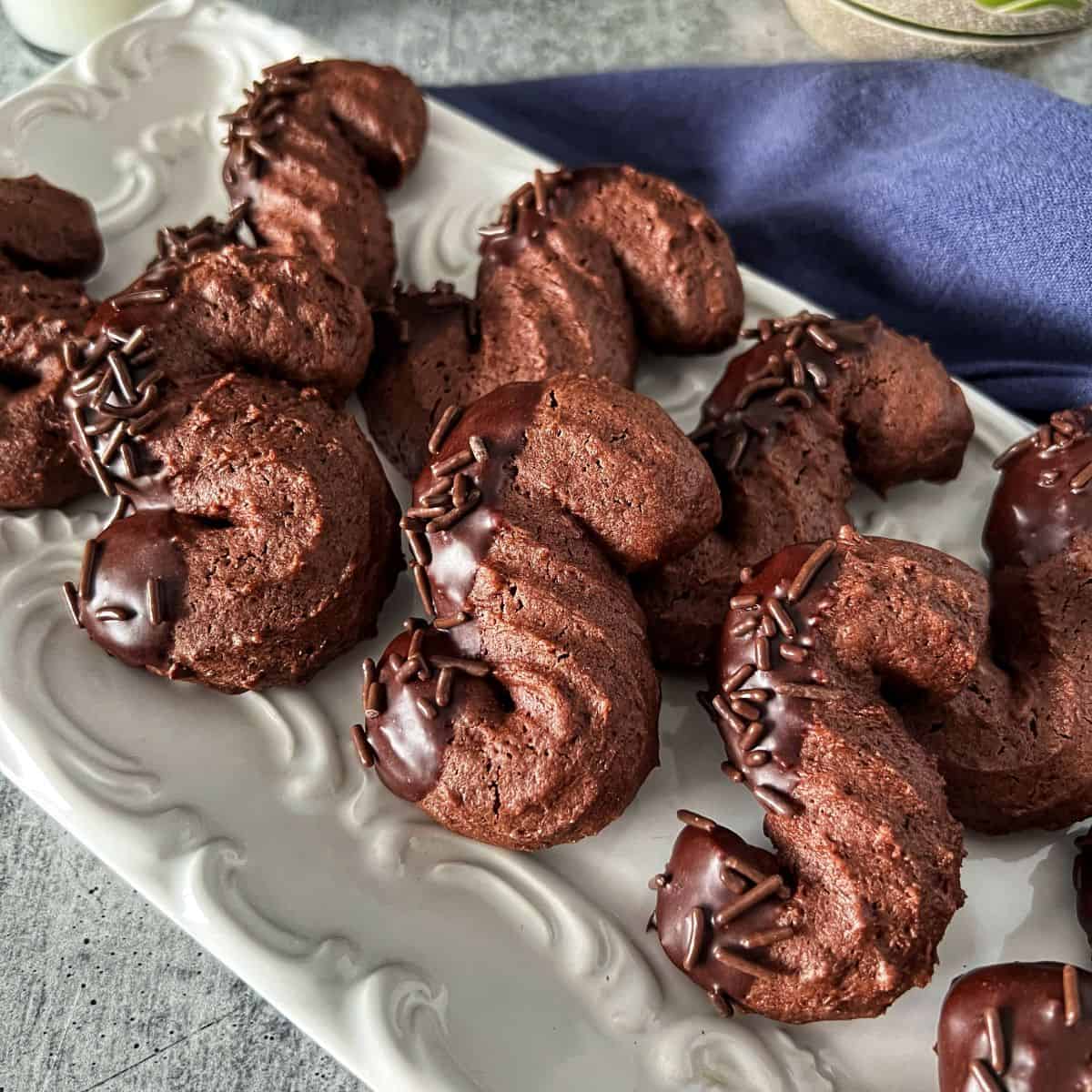 Chocolate S cookies on a white platter.