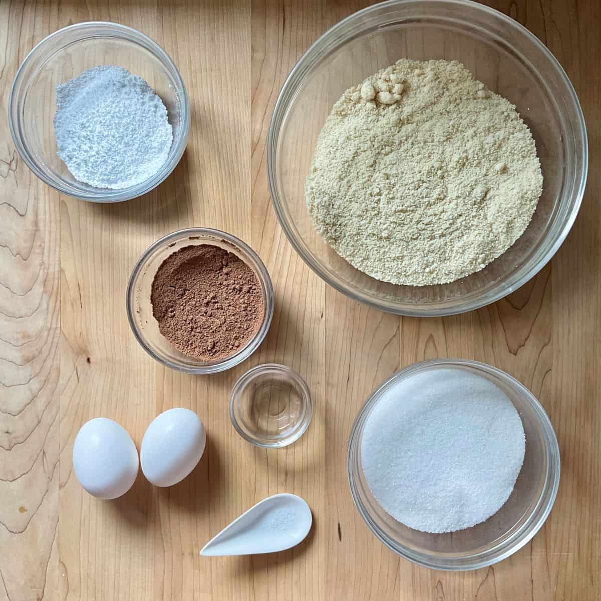Ingredients to make chocolate amaretti cookies including almond flour and cocoa
