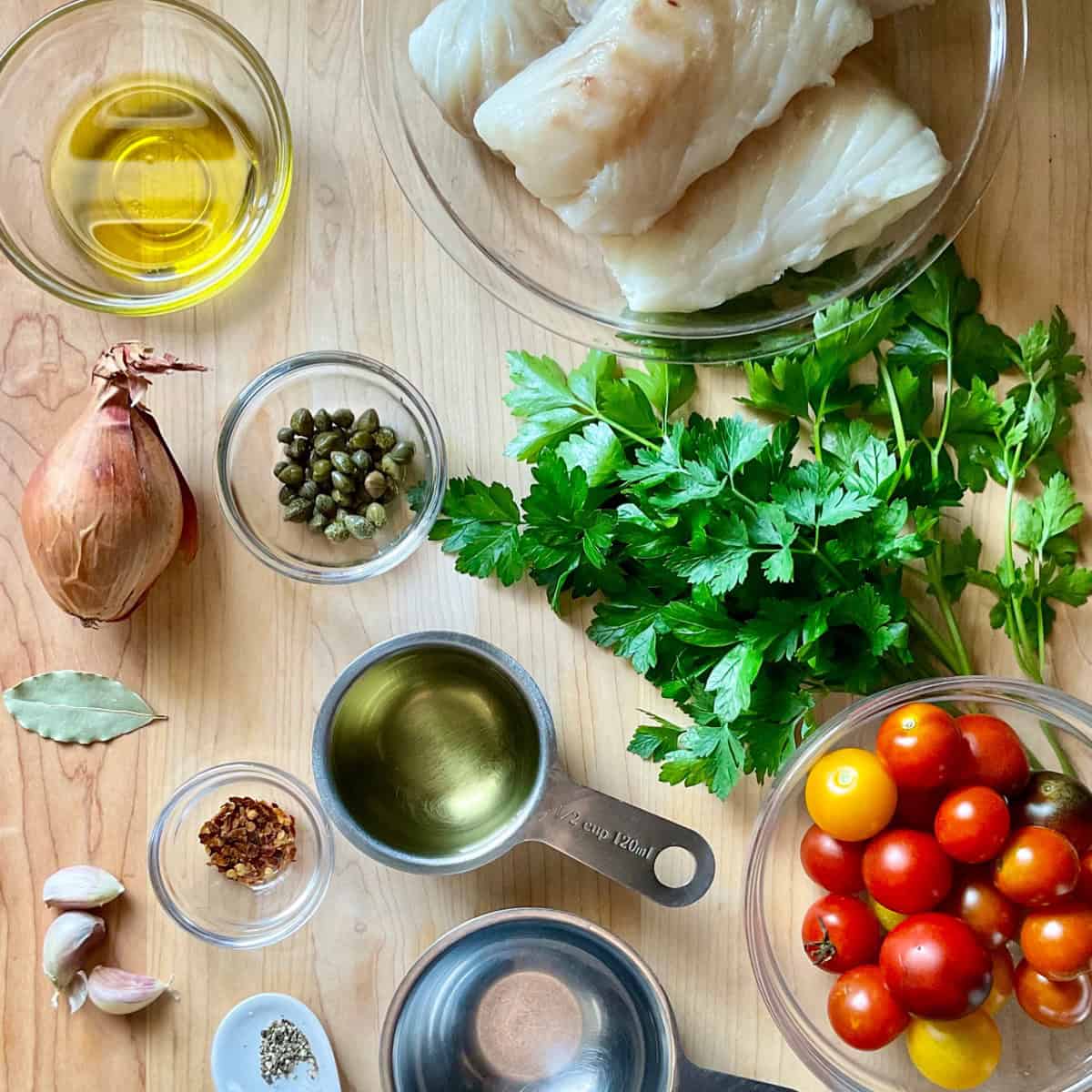 Ingredients to make acqua pazza recipe on a wooden board